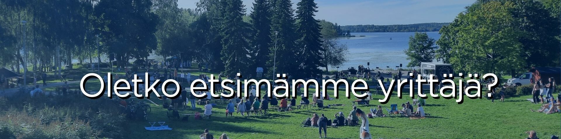 Myllyrannan tapahtumapuiston nurmirinteessä ihmisiävistumassa tapahtumaa seuraten.